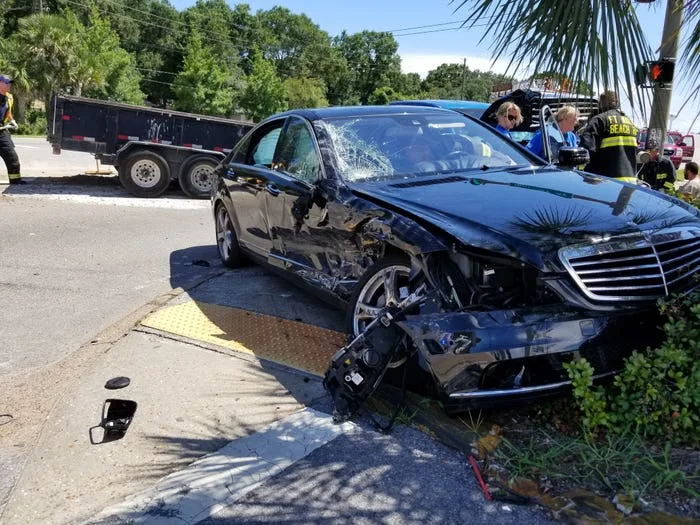 Wrecked black sedan after a serious car accident at a Georgia intersection - Atlanta auto accident attorney